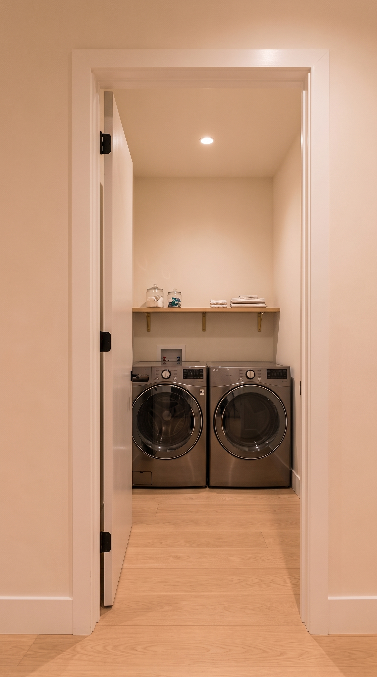 Haj Riyadh second-floor laundry with side-by-side washer and dryer viewed through its single corridor doorway
